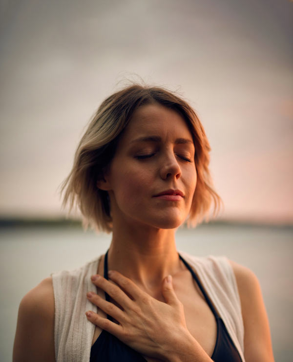 femme détendue, avec la main sur la poitrine et les yeux fermés